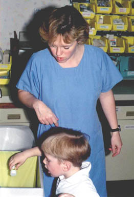 Christopher helps a nurse with her tasks.